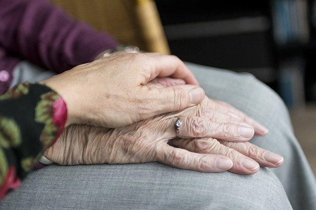 Woman holding elderly womans hand